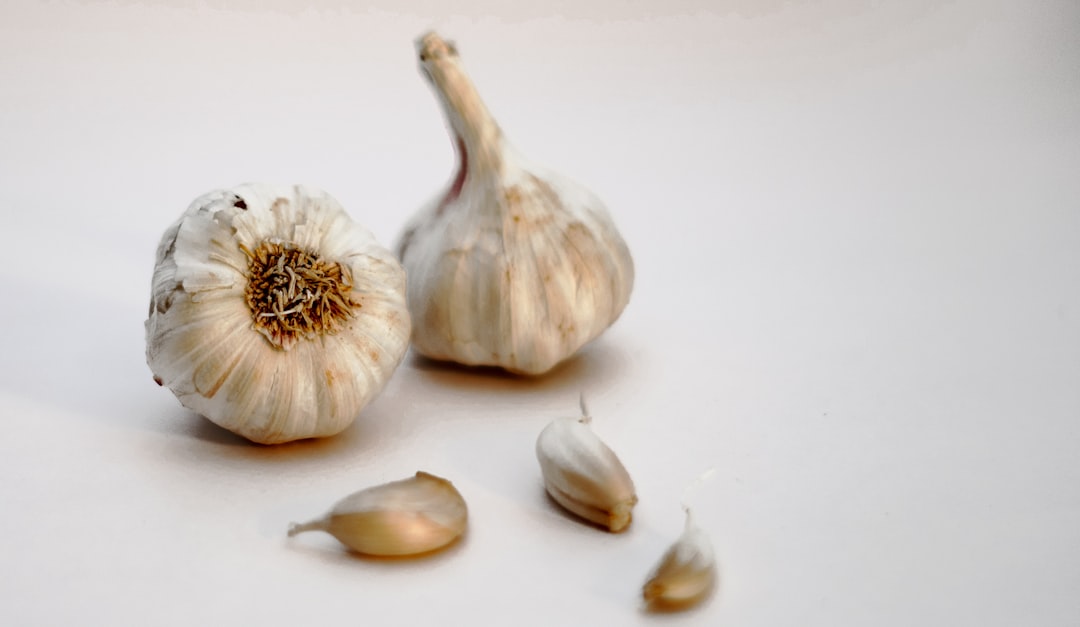 Photo by Sanjay Dosajh garlic bulb and garlic on white surface